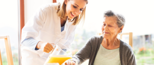 caregiver giving a juice to the senior woman