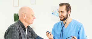 nurse using a statoscope to check the heartbeat of the senior man