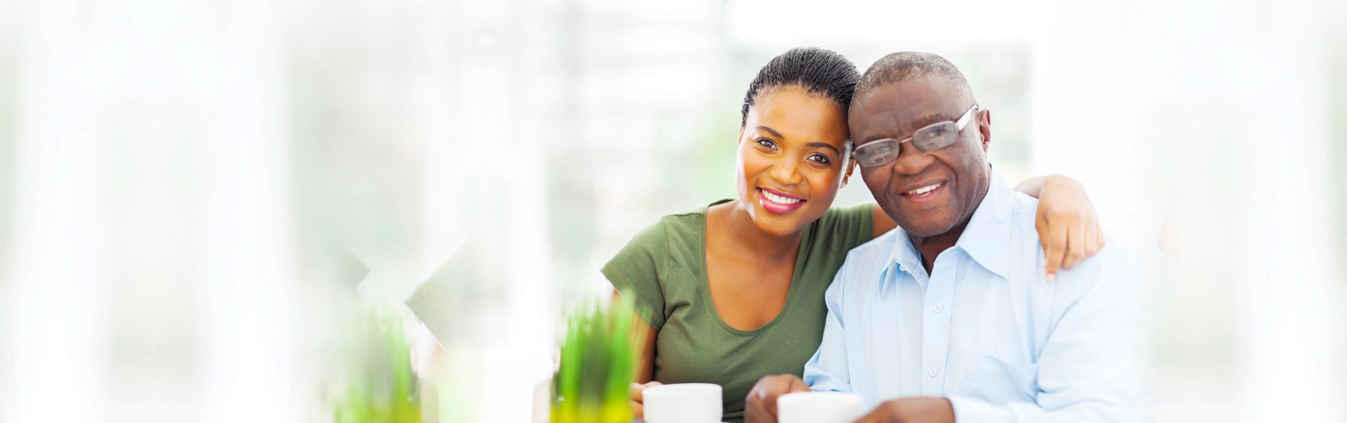 caregiver and senior man are smiling